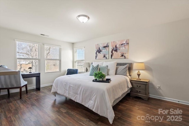 bedroom with visible vents, wood finished floors, and baseboards