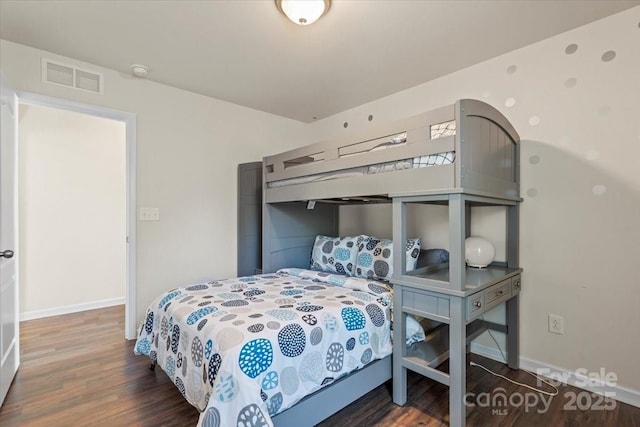 bedroom featuring visible vents, baseboards, and wood finished floors