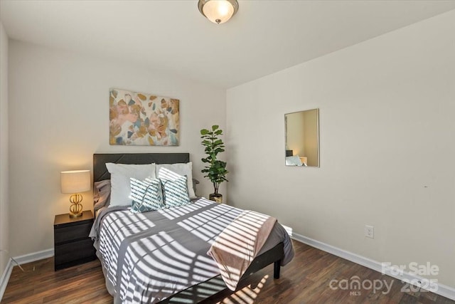 bedroom featuring baseboards and wood finished floors