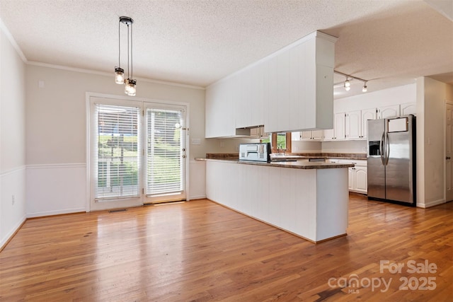 kitchen with stainless steel fridge with ice dispenser, dark countertops, a peninsula, and a textured ceiling