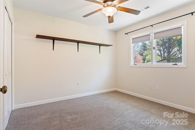 carpeted empty room featuring visible vents, baseboards, and ceiling fan