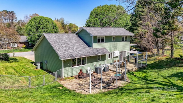 back of house featuring a lawn, central AC unit, a gate, and a shingled roof