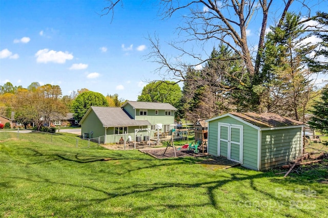 view of yard with a storage shed, fence, and an outbuilding