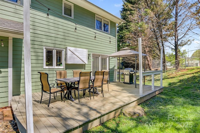 deck with a gazebo, a yard, fence, and outdoor dining space