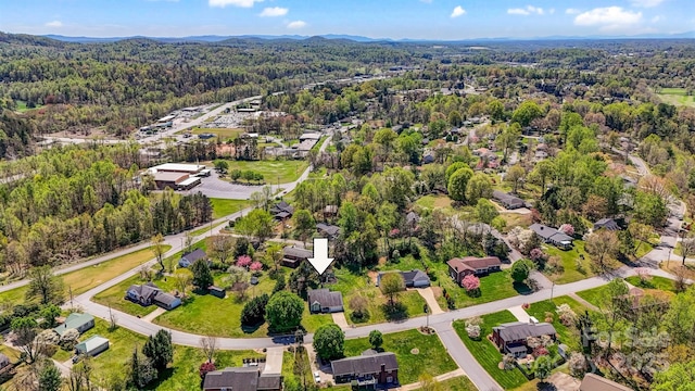 drone / aerial view featuring a wooded view and a residential view