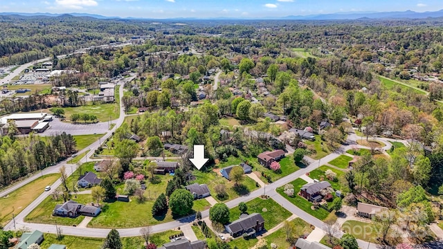 birds eye view of property featuring a forest view and a mountain view