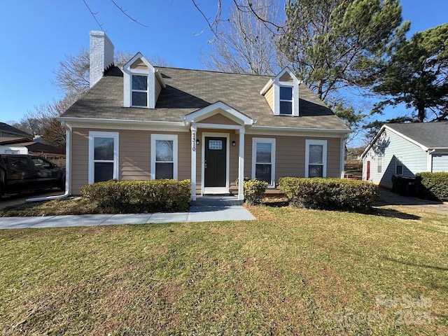 cape cod house with a front lawn and a chimney