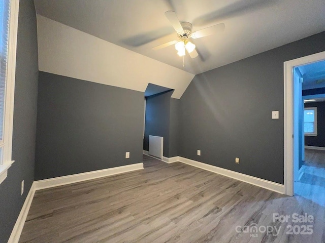 bonus room featuring ceiling fan, baseboards, wood finished floors, and vaulted ceiling