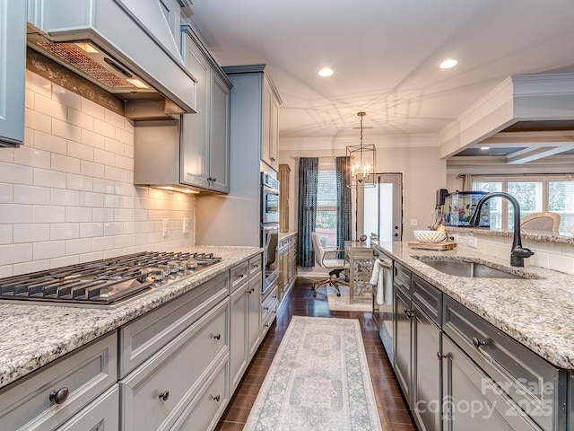 kitchen featuring premium range hood, ornamental molding, a sink, an inviting chandelier, and appliances with stainless steel finishes