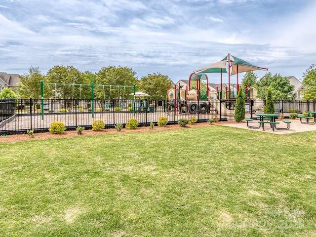 community jungle gym featuring a lawn and fence