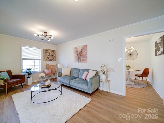 living area with an inviting chandelier, crown molding, light wood-style floors, and baseboards