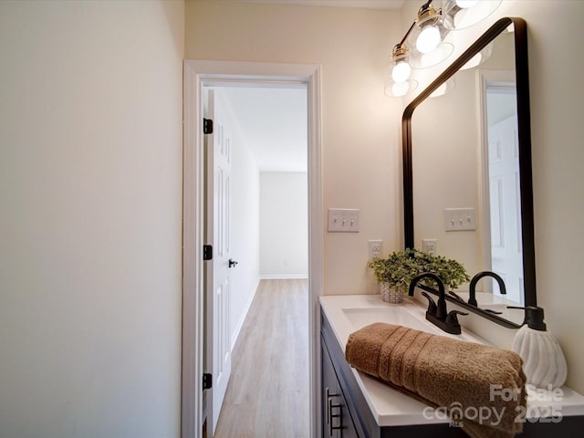 bathroom featuring vanity, wood finished floors, and baseboards