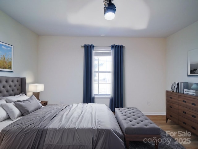 bedroom with baseboards and wood finished floors