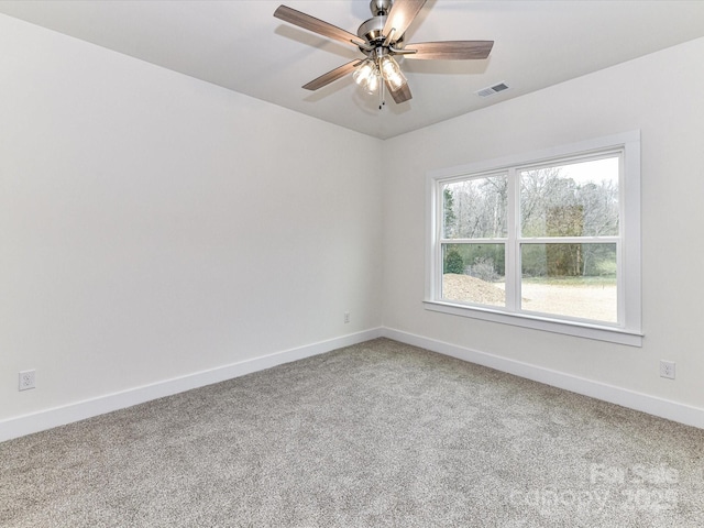 carpeted empty room with visible vents, a ceiling fan, and baseboards