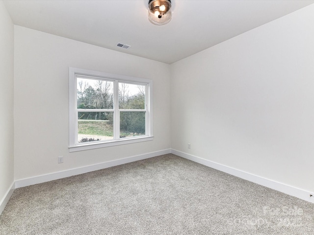 carpeted empty room with visible vents and baseboards