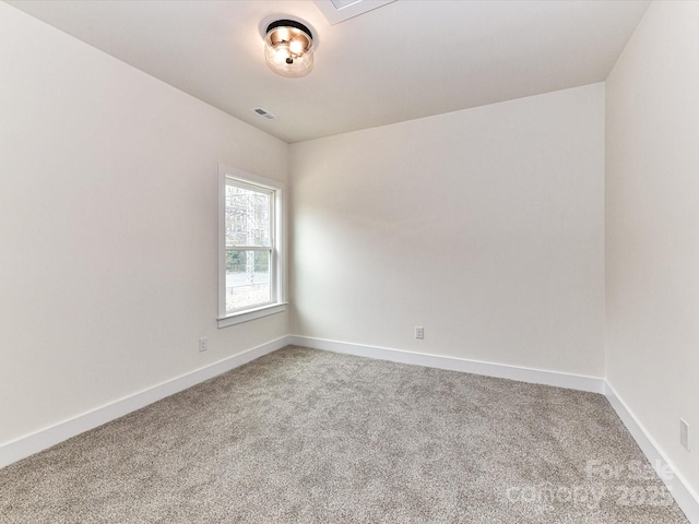 empty room featuring visible vents, baseboards, and carpet