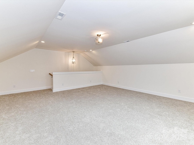 additional living space with visible vents, baseboards, and lofted ceiling