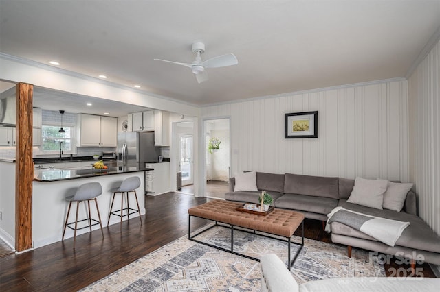 living area featuring recessed lighting, ornamental molding, ceiling fan, and dark wood-style flooring