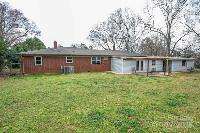 back of property featuring crawl space, a patio, a yard, and a chimney