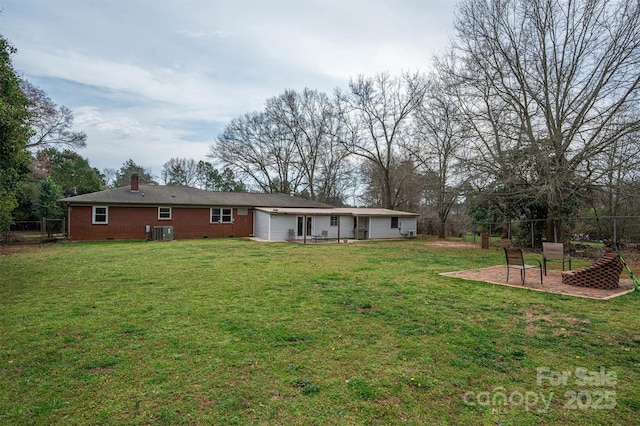 back of house with fence, central AC unit, a lawn, a chimney, and a patio