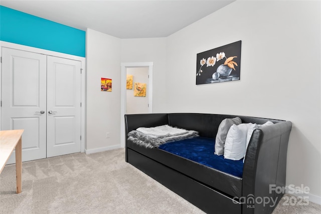 bedroom with baseboards, carpet floors, and a closet