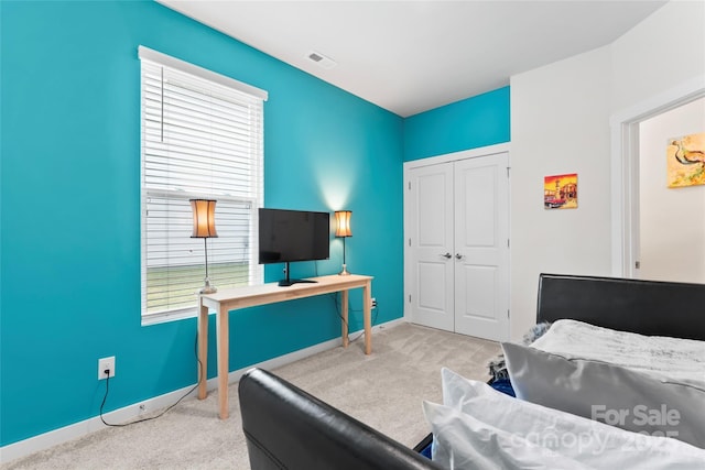 bedroom featuring a closet, visible vents, baseboards, and carpet