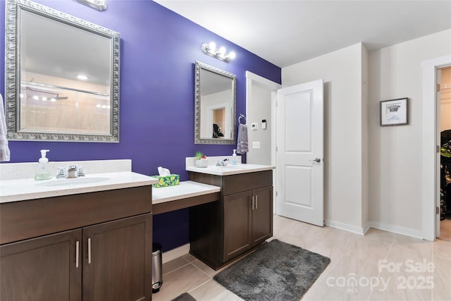 bathroom featuring a sink, two vanities, and tile patterned floors