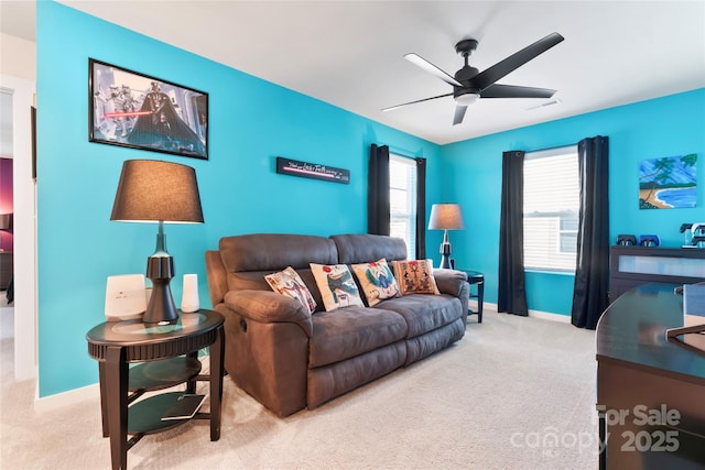 carpeted living area with baseboards, visible vents, and ceiling fan