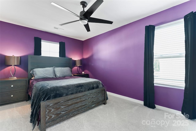 carpeted bedroom featuring visible vents, baseboards, and ceiling fan