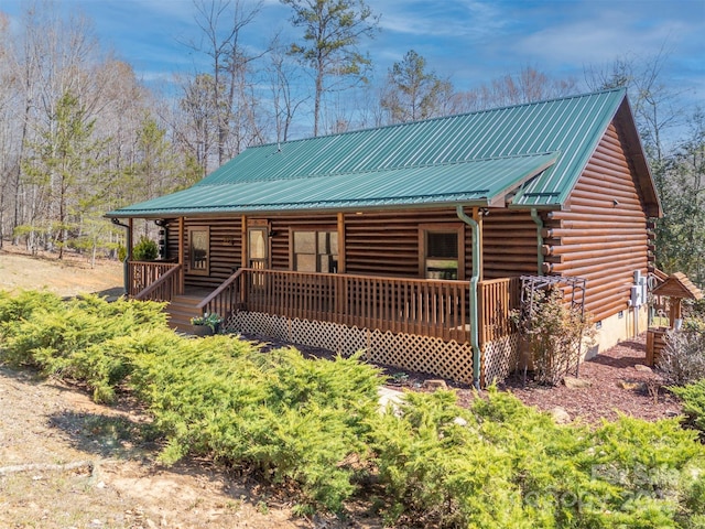 log-style house featuring covered porch, crawl space, log siding, and metal roof