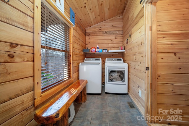 clothes washing area with laundry area, wood walls, visible vents, washer and dryer, and wood ceiling