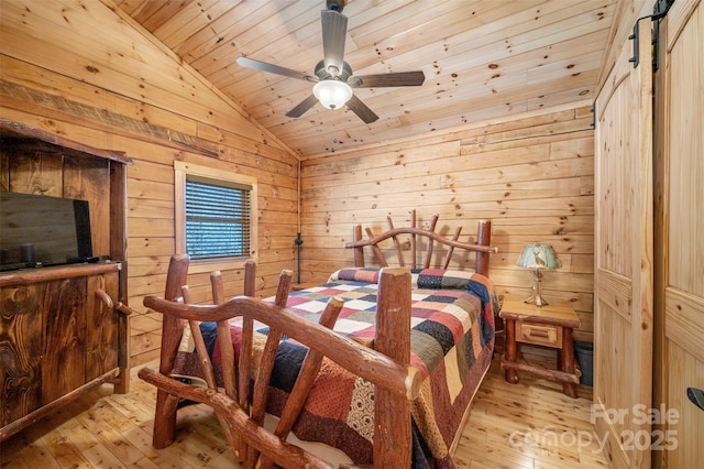 bedroom with light wood-type flooring, wood walls, wood ceiling, and vaulted ceiling