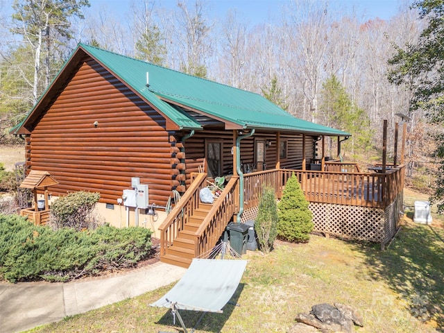 back of house featuring a deck, log siding, and metal roof