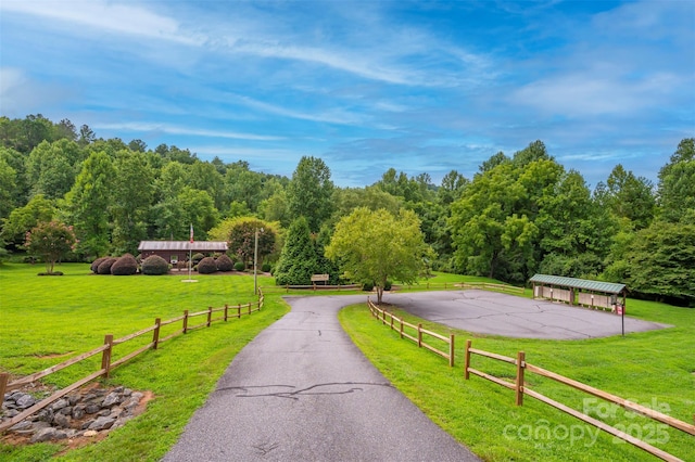 view of community with a lawn and fence