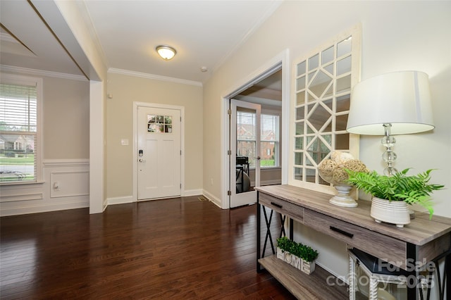 foyer entrance with a wainscoted wall, dark wood-type flooring, and crown molding