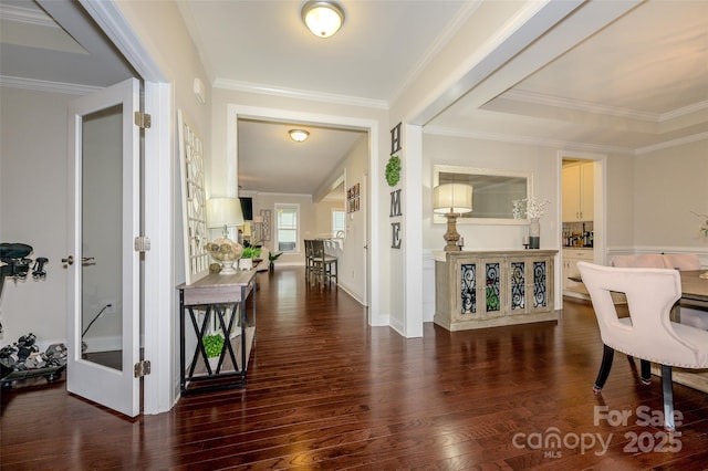 entryway with baseboards, wood finished floors, and crown molding