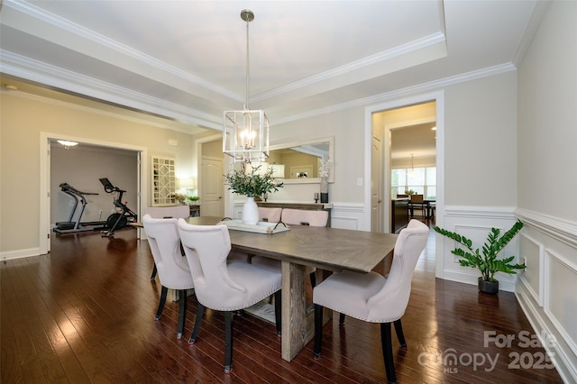 dining room featuring a wainscoted wall, a notable chandelier, dark wood-style flooring, and a decorative wall