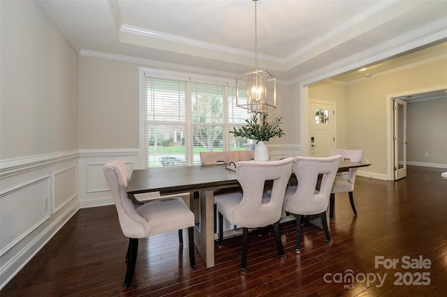 dining area with a decorative wall, a notable chandelier, crown molding, and dark wood-type flooring