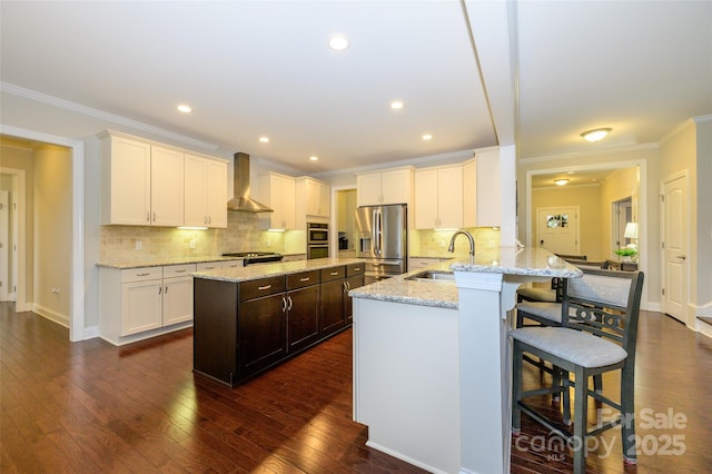 kitchen with a kitchen bar, dark wood-type flooring, stainless steel refrigerator with ice dispenser, a sink, and wall chimney range hood