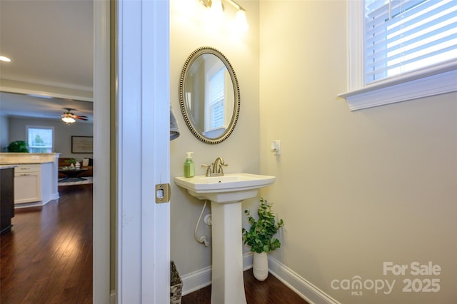 bathroom with plenty of natural light, ceiling fan, baseboards, and wood finished floors