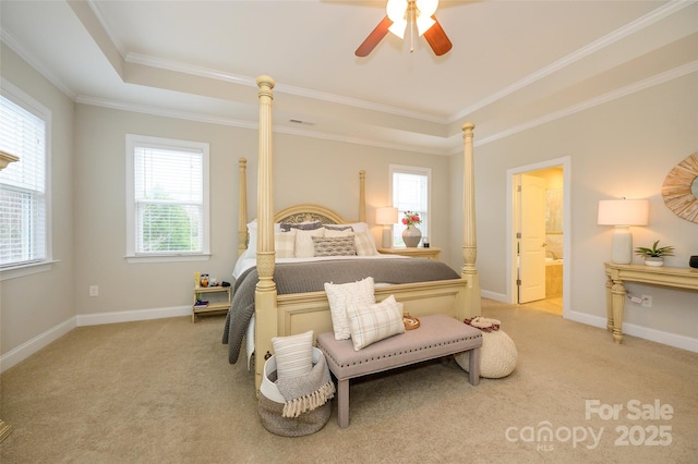 bedroom with a tray ceiling, baseboards, light colored carpet, and crown molding