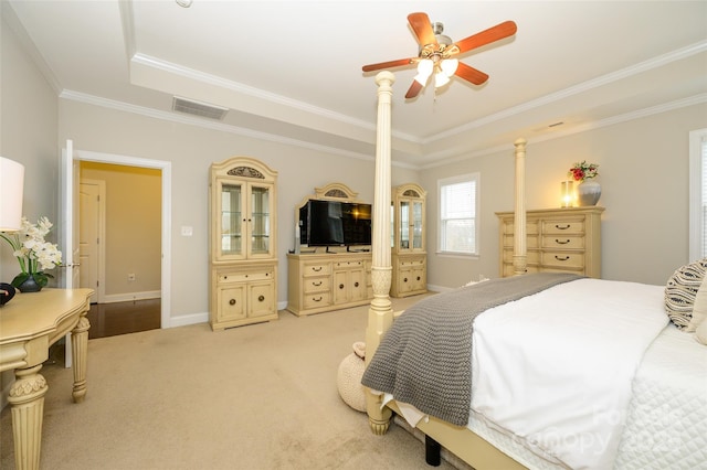 bedroom featuring visible vents, a tray ceiling, crown molding, baseboards, and light colored carpet