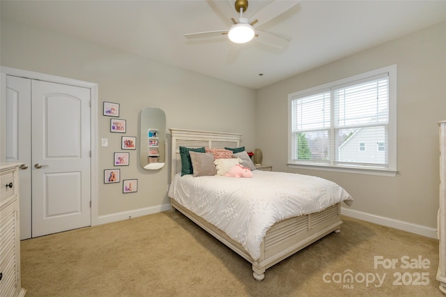 bedroom with light colored carpet, baseboards, and ceiling fan