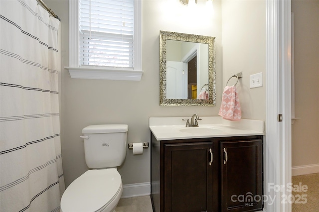 bathroom with vanity, toilet, a shower with curtain, and baseboards