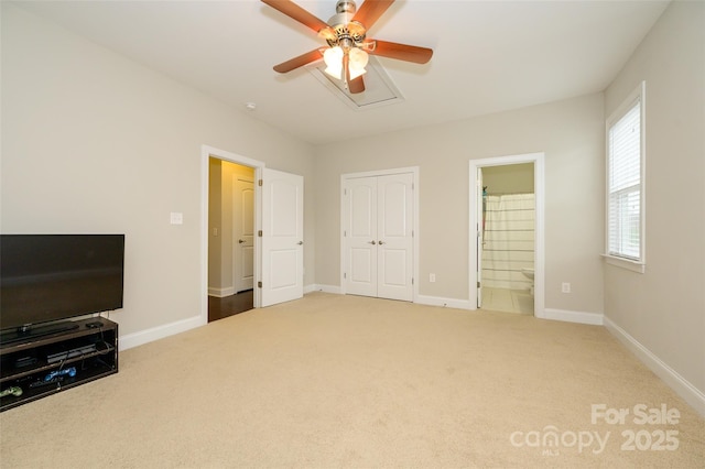 carpeted bedroom featuring ensuite bathroom, baseboards, a closet, and ceiling fan