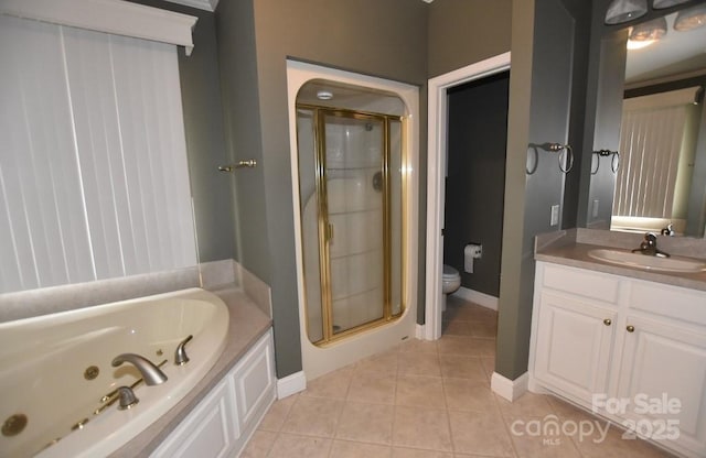 bathroom with vanity, a stall shower, tile patterned floors, a jetted tub, and toilet