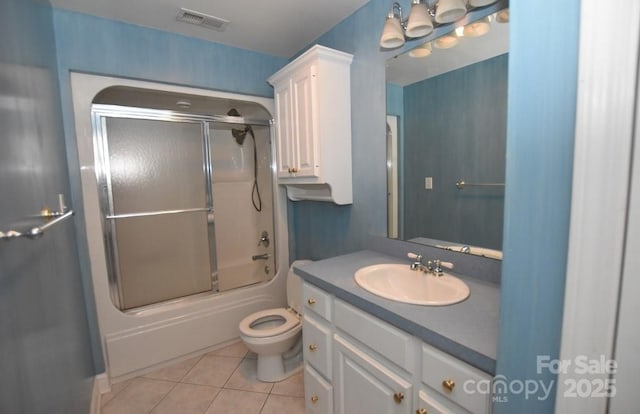 bathroom featuring visible vents, toilet, tile patterned floors, combined bath / shower with glass door, and vanity