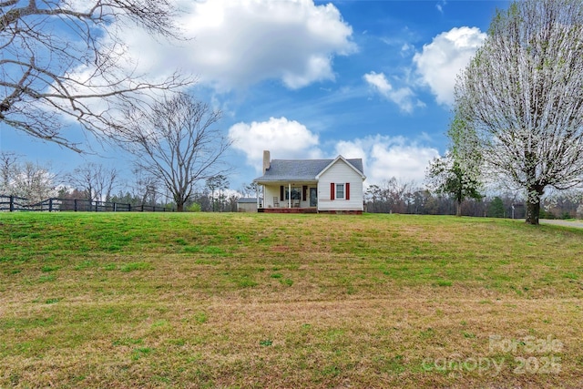 view of front of property featuring a wooden deck, a chimney, a front lawn, and fence