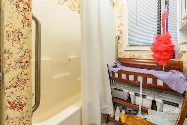 bathroom featuring wallpapered walls and shower / tub combo