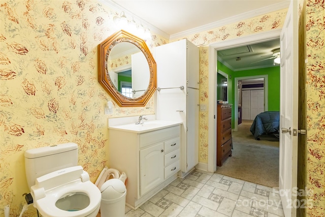 bathroom with wallpapered walls, baseboards, toilet, ornamental molding, and vanity